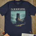 Navy fantasy T-shirt with a misty watchtower illustration and I'll Be In My Office text