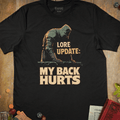 Black tabletop RPG T-shirt with a hooded rogue leaning on a railing and Lore Update My Back Hurts text