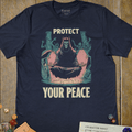 Navy blue fantasy T-shirt with a hooded horned figure meditating and protect your peace text